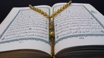 close up of opened Holy Quran and rosary . Ramadan theme