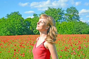 Naklejka na ściany i meble Young woman with closed eyes in poppy field
