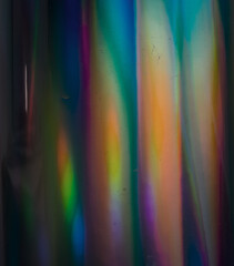 Holo background with multiple colors. Fantasy rainbow texture. Real photo flash hitting curved...