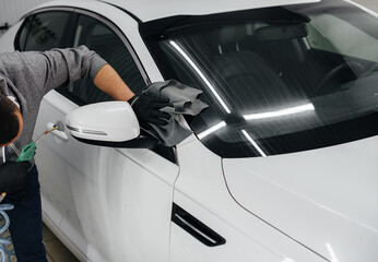 An employee blows and wipes the car after washing. Car wash