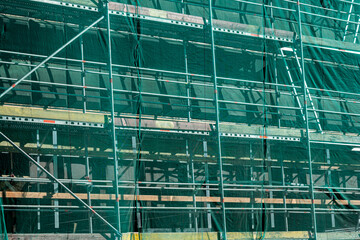 scaffolding covered in green mesh. Construction or repair work. perspective view.