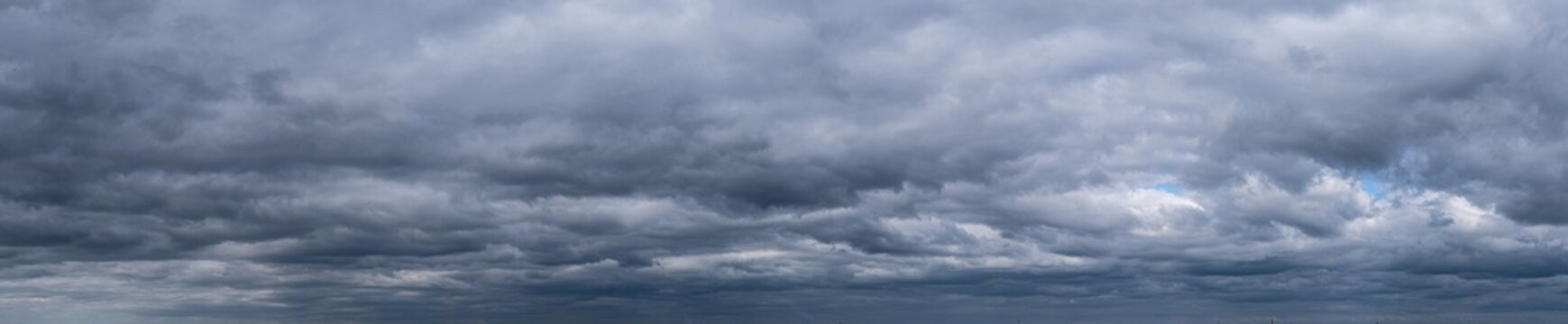 panorama of dramatic sky with clouds before a thunderstorm. Dark abstract background.