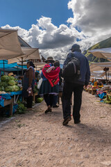 Picture from the back of a Peruvian man and woman at local market in Pisac village from Peru. - obrazy, fototapety, plakaty