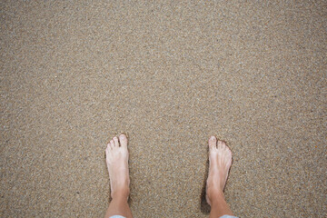 men's feet on the fine brown sand