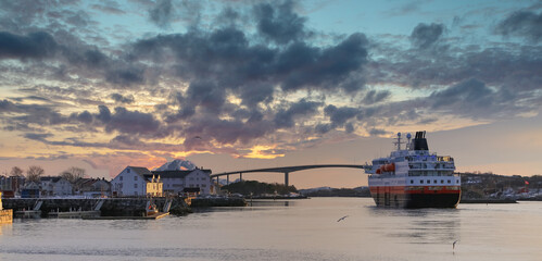 Coastal ships depart from Bronnoysund harbor in sunset, Northern Norway