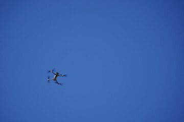 Unmanned drone flying in the air, blue background.