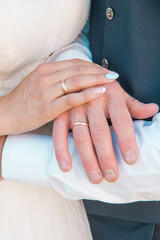 Hands of the bride and groom with rings, closeup. Details of a wedding clothes. Wedding theme, wedding ceremony. Vertical view
