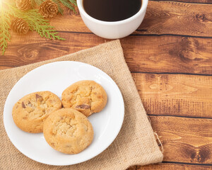 Flat lay Office table brown wooden desk with warm light, Bright Creative workspace with black coffee, A cookie is a baked or cooked food that is typically small, flat and sweet, with copy space