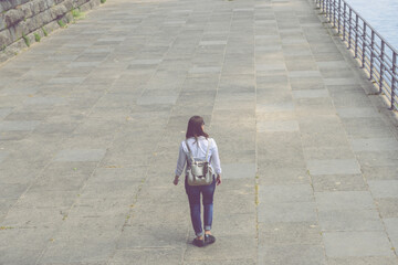 Young Woman Standing, Walking On Promenade By River In City During Summer