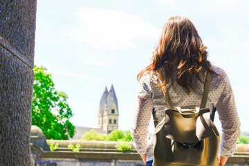 Woman standing between walls and looking outside  to a cityscape view