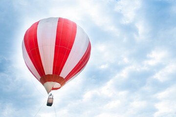 Naklejka premium Balloon in the blue sky. Red balloon in the blue cloudy sky.