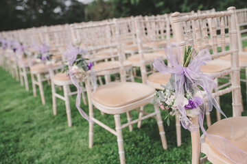 Wedding ceremony outside with decorated chairs