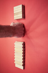 Hand stopping wooden domino business crisis effect or risk protection concept