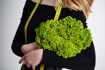 Diet concept, woman holding green broccoli measuring tape