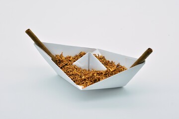 Barco de papel cargado de tabaco sobre fondo blanco