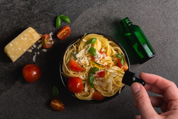 Cannabis CBD spaghetti pasta overhead food photography on black background. Made with CBD infused marijuana oil. Cannabis edibles for medication or recreational enjoyment of weed. Eating your pot.