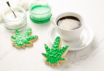 Cannabis cookies overhead on white marble. THC or CBD baking weed cookies flat lay. Cannabis edibles for medical or recreational consumption. Made with cannabis infused oil and royal icing.