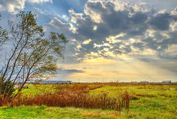 overgrown field bathed in sunlight bursting through the clouds, busy highway 55 in the distance with rays of light shining down, Litchfield Illinois