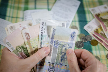 Man at home recounts money after going to the store. Men's hands close-up. Russian rubles
