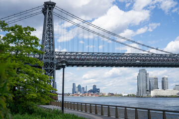 An empty promenade along East River in lower Manhattan with a view of Williamsburg Bridge