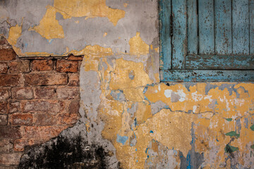 old brick wall with cracks and wooden window