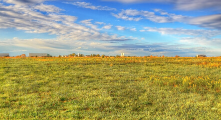 semi trucks moving across the prairie state with golden hued green fields beneath a blue and white cloudy sky, Highway 55, Litchfield Illinois 