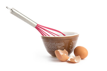 a red hand whisk with a bowl and brown eggs isolated on white
