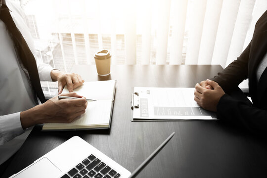 Interview employee talking about resume and job description with the job seeker sitting in front