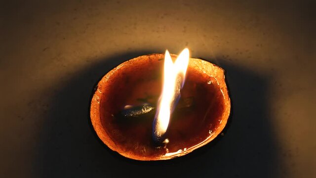 Spiritual flame natural candle burning on dark background Up Close Top View with Palo Santo wick for Smoke Clearing Energy Work Healing Aura in a Coconut Shell Beeswax Fuel Real Fire in 4k