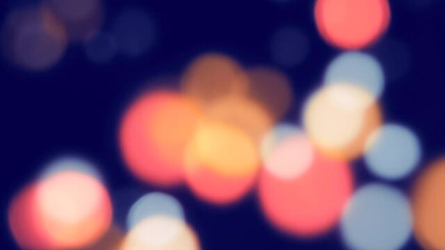 Beautiful abstract and colorful group of unfocused golden, blue and red bokeh lights moving across the pitch black space in active night life of city center