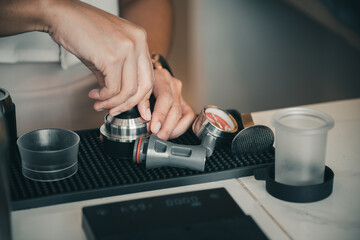 The hand of a female barista is producing quality coffee.