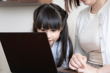 ノートパソコンを見る親子