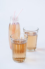 Two glasses and a bottle with Apple juice tubes on a white background