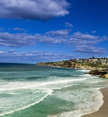 Tamarama Beach in Sydney NSW Australia on a sunny winters day partly cloudy skies Pacific Ocean waves and nice sandy beach