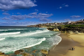 Tamarama Beach in Sydney NSW Australia on a sunny winters day partly cloudy skies Pacific Ocean waves and nice sandy beach