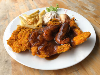 Chicken chop consist of deep fried french fries with chicken breast tender meat fresh organic mayo coleslaw, cajun shrimp and bread on plain white plate
