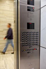 View from inside elevator with door open and man walking quickly by © Dennis M. Swanson