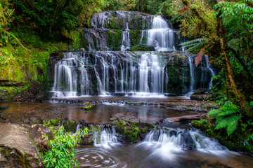 The Beautiful Purakaunui waterfall all in the lush dense native bush and forest of the Catlins in Southern New Zealand
