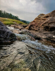 Natuaral water is flowing over natuaral rocks. Beautiful landscape with scenic environment