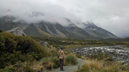 A man walking inside Mount Cook National Park in New Zealand