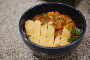 Close up of chicken katsu curry in a bowl.