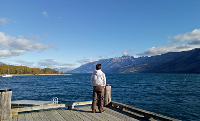 Fototapeta na wymiar A man standing around lake Wakatipu New Zealand