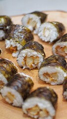 Close up of sushi with wooden plate as background.