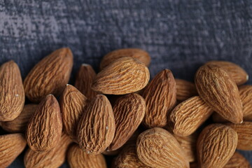 Almond nut close-up on a gray wooden shabby background.Vegetarian and vegan food.  Healthy fats . Wholesome food and snack.