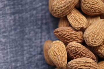 Almond nut close-up on a gray wooden shabby background.Vegetarian and vegan food.  Healthy fats ingredient. Wholesome  snack.