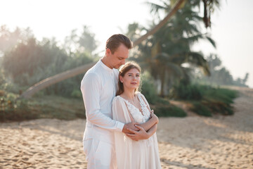 Happy just married young wedding couple celebrating and have fun at beautiful beach sunset. Attractive young bride and groom hugging on the beach. Wedding couple. Just married