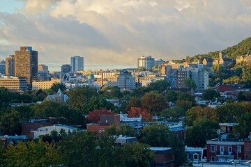 Obraz premium View of the part of the ascent of mount Royal, which is closer to Down Town, taken on a long lens from the side of the Plateau area from the 10th floor. Colourful trees around mount Royal
