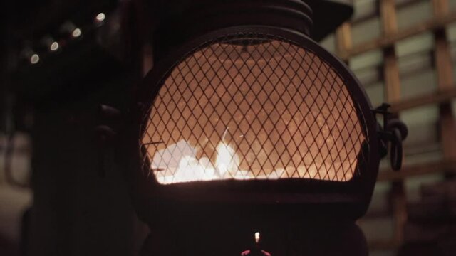 Cast iron log burner in garden at night time, medium shot, Time Lapse