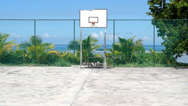 Derelict basketball court on a tropical island, waves and beautiful ocean in the background