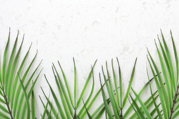 Obraz na płótnie Canvas Palm leaves on white quartz countertop with copy space, flat lay
